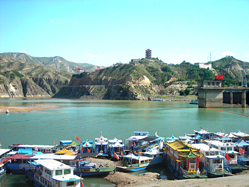 Stuwmeer. Vertrekpunt per boot over de rivier tussen de bergen door naar de Bing Ling Cave Temple. Ca. 60 km van Lanzhou verwijderd.